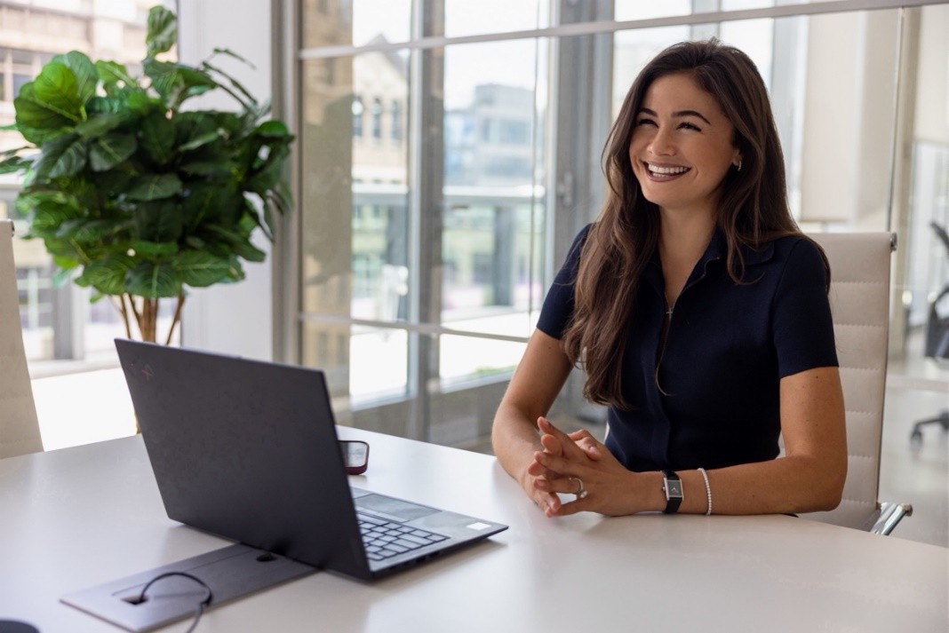 Shannon Westhead sitting at a desk with a laptop, smiling